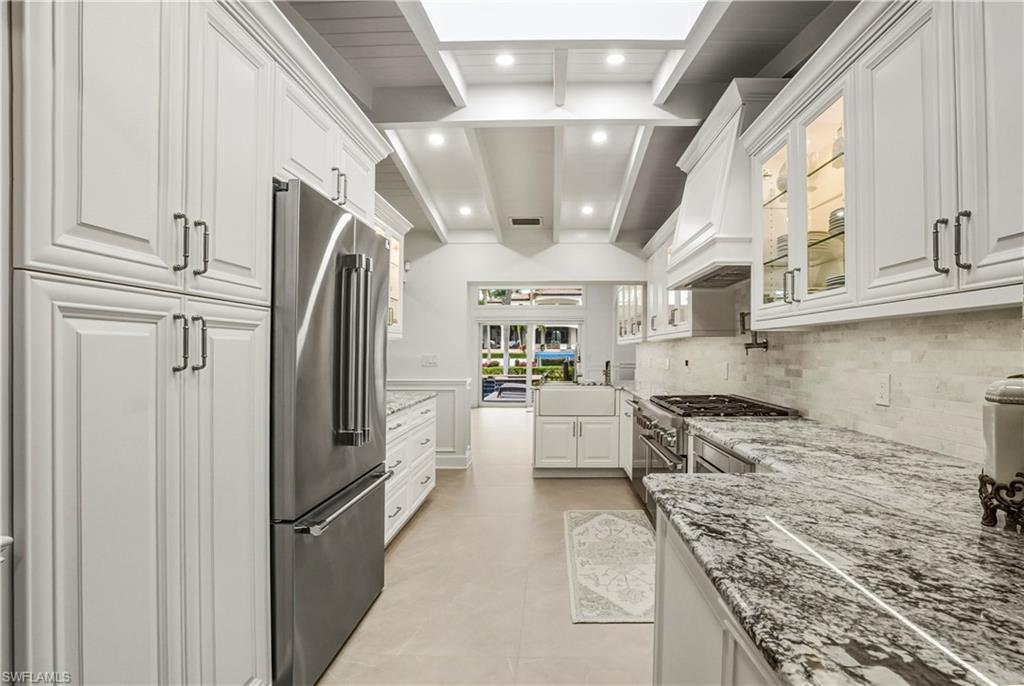 453 18th Avenue South Naples, FL 34102 - Photo 7 of 47 a kitchen with stainless steel appliances granite countertop a refrigerator a stove and a sink with cabinets