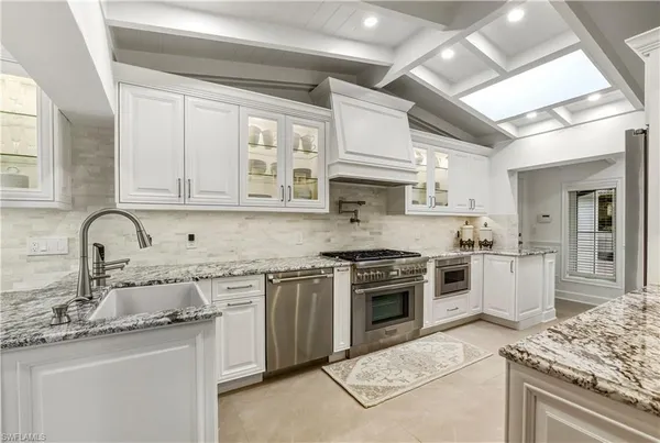 a kitchen with stainless steel appliances granite countertop a sink stove and cabinets
