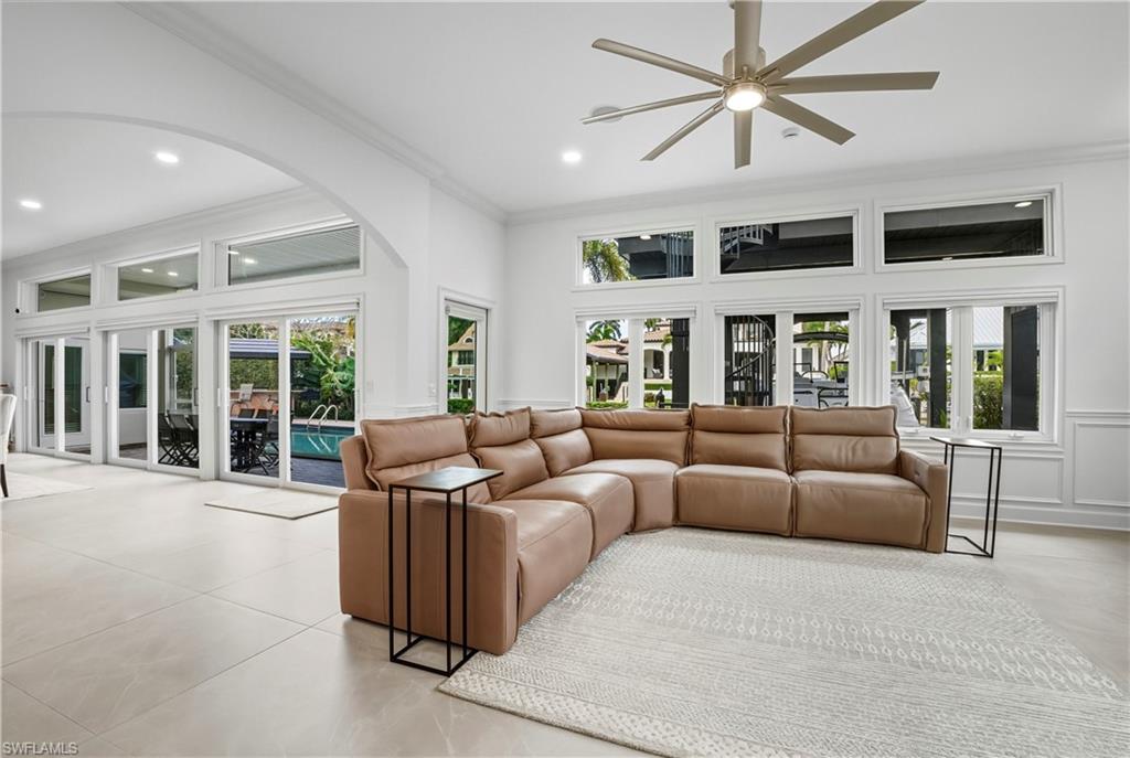 453 18th Avenue South Naples, FL 34102 - Photo 10 of 47 a living room with furniture large windows and a chandelier