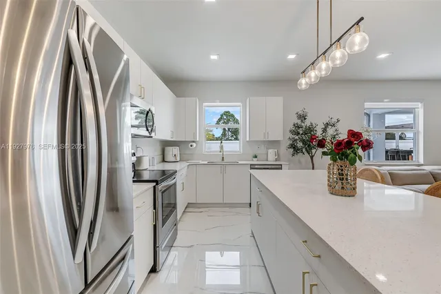 a kitchen with white cabinets and stainless steel appliances