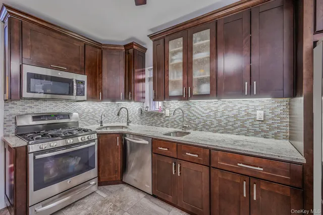 a kitchen with stainless steel appliances granite countertop a stove and a sink
