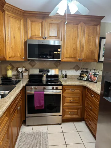 a kitchen with stainless steel appliances granite countertop a stove a sink and a microwave