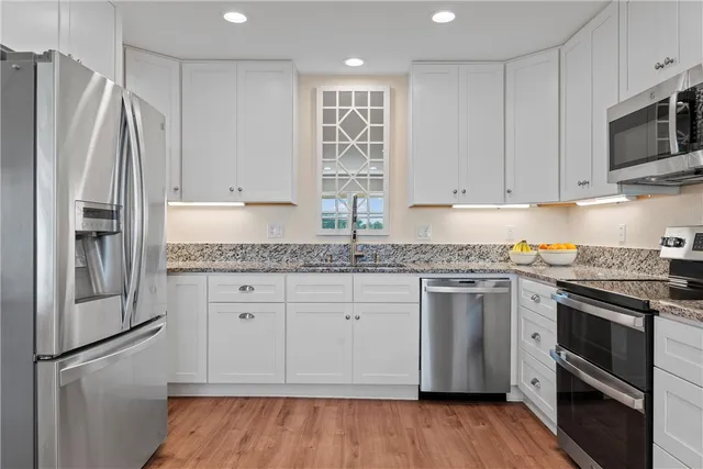 a bathroom with a granite countertop sink a toilet and a large mirror