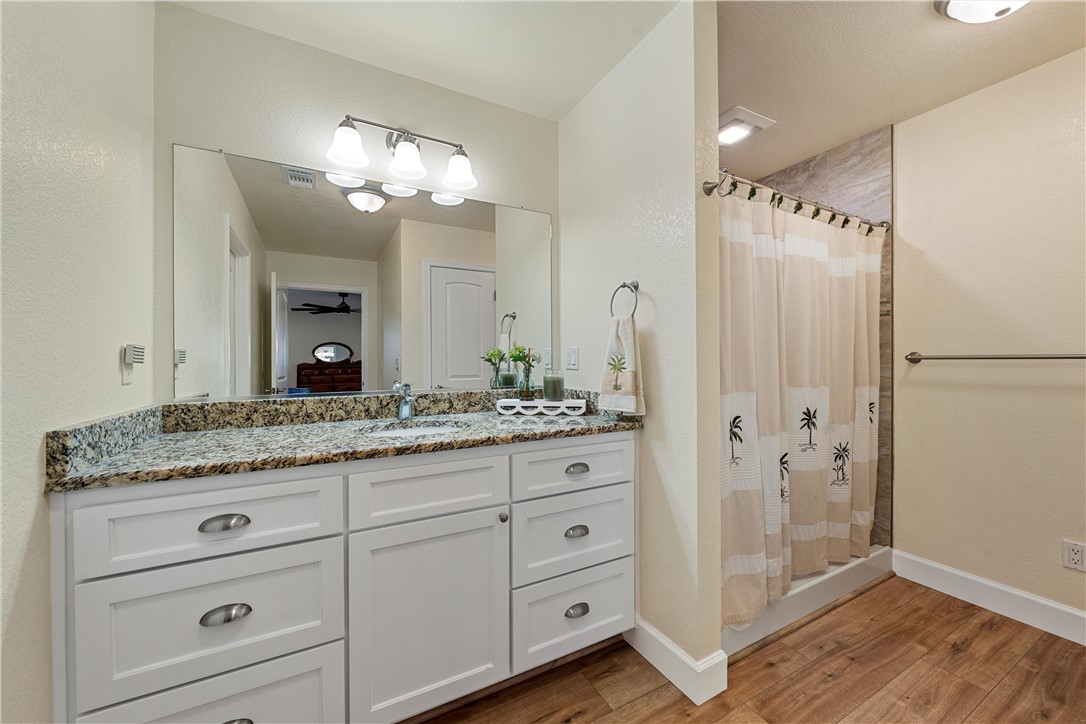 1748 Downsville Road Robinson, TX 76706 - Photo 27 of 65 a bathroom with a granite countertop sink a mirror and a shower