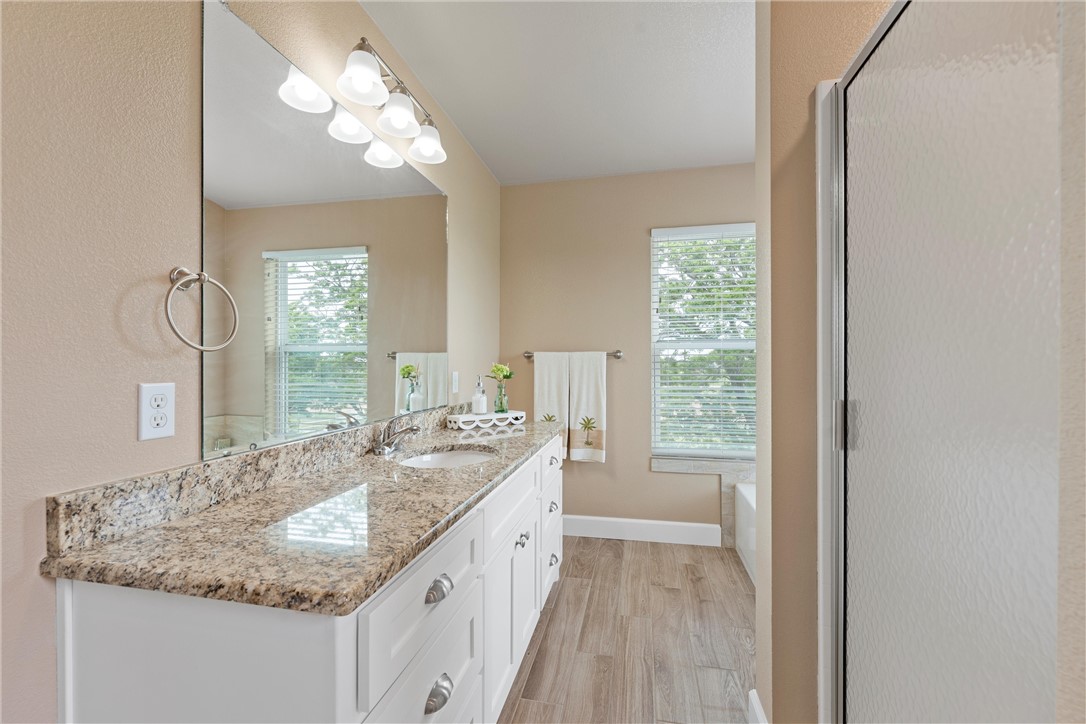 1748 Downsville Road Robinson, TX 76706 - Photo 37 of 65 a bathroom with a granite countertop sink a large mirror and a window