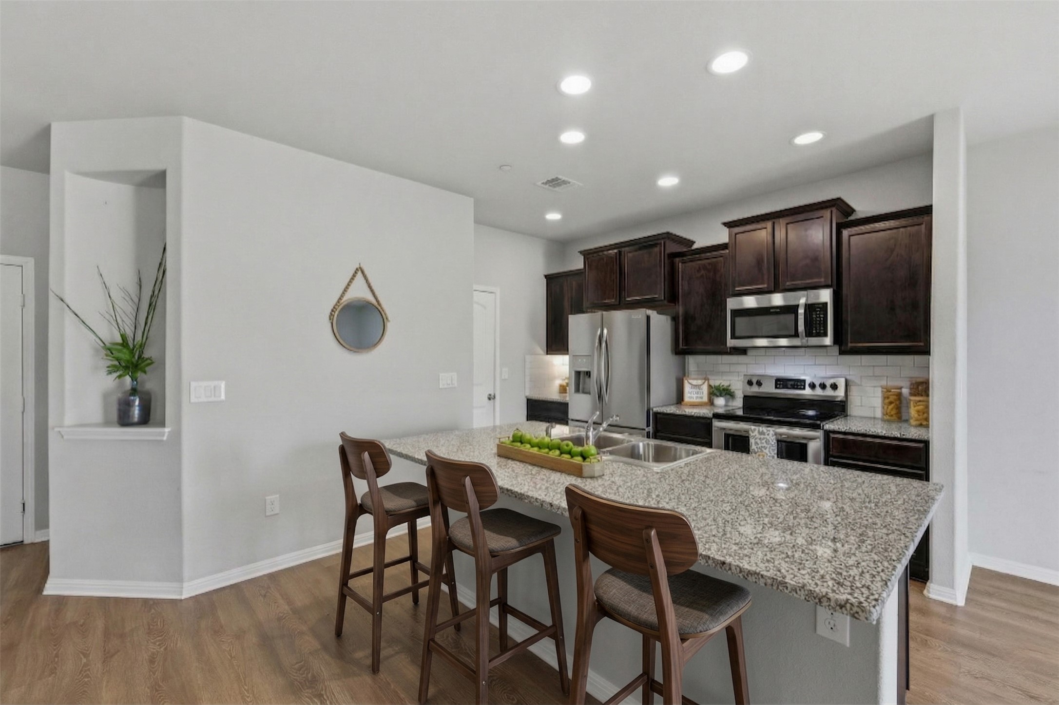 516 East Slaughter Lane, Unit 2402 Austin, TX 78744 - Photo 6 of 27 a kitchen with stainless steel appliances granite countertop a kitchen island hardwood floor and chairs