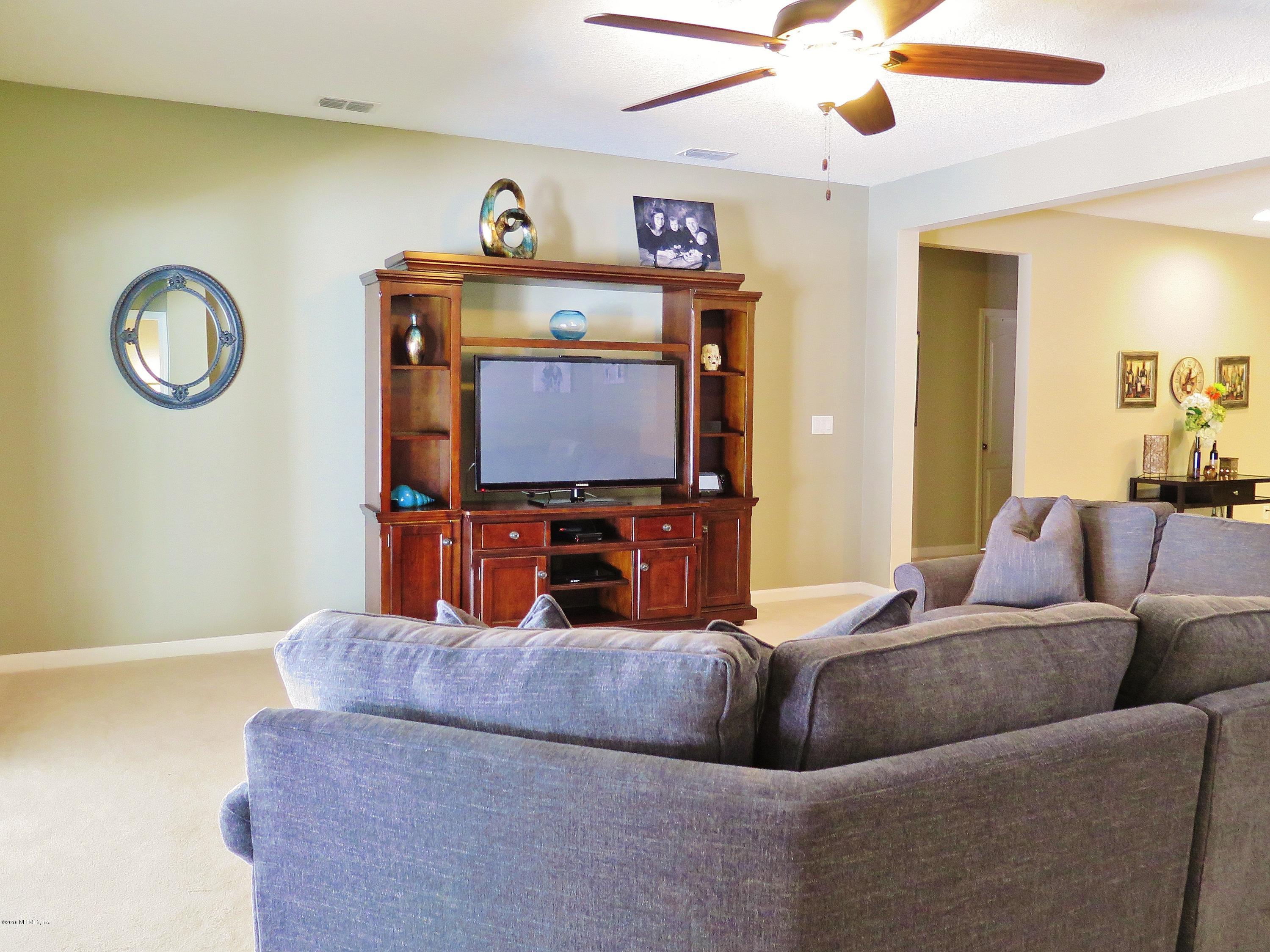 16504 Tisons Bluff Road Jacksonville, FL 32218 - Photo 12 of 34 a living room with furniture and a flat screen tv