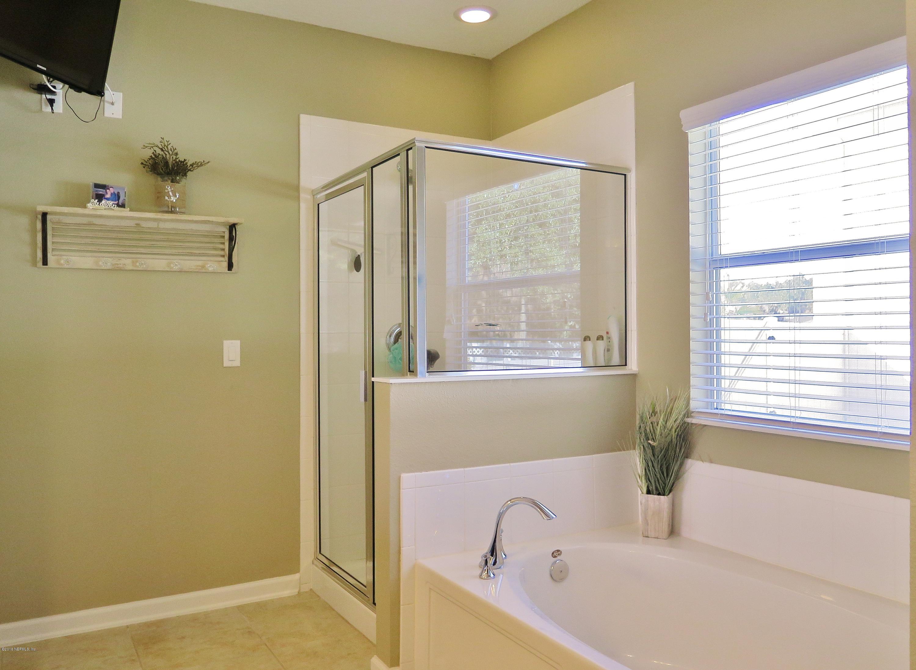 16504 Tisons Bluff Road Jacksonville, FL 32218 - Photo 15 of 34 a bathroom with a bathtub and a window