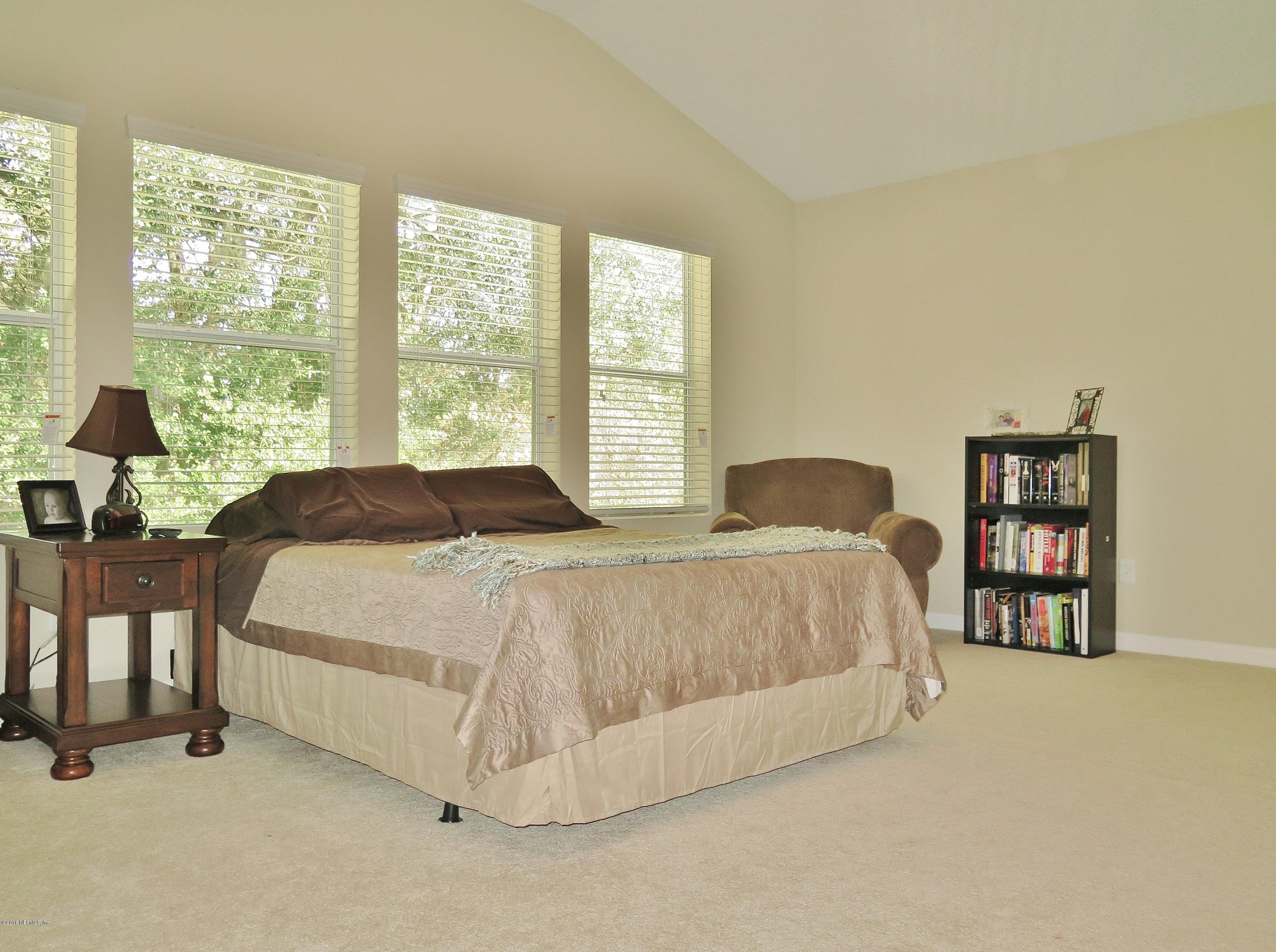 16504 Tisons Bluff Road Jacksonville, FL 32218 - Photo 19 of 34 a spacious bedroom with a bed and a large window