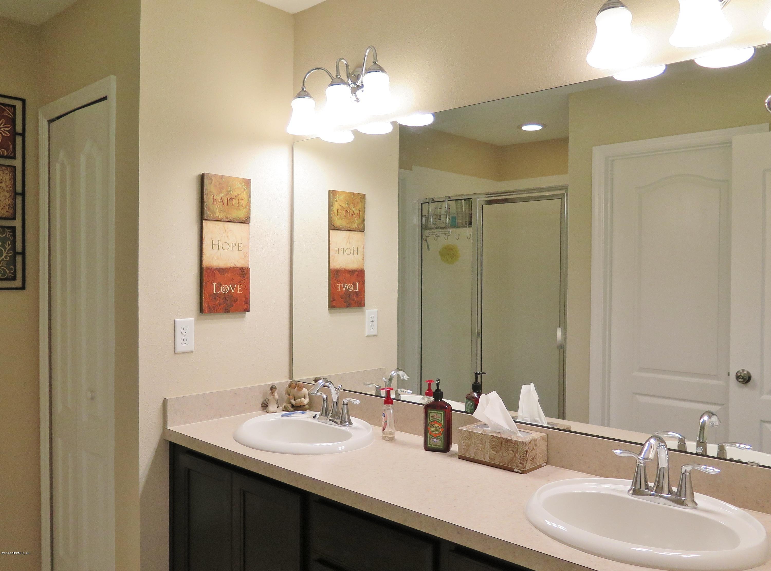 16504 Tisons Bluff Road Jacksonville, FL 32218 - Photo 20 of 34 a bathroom with double vanity sinks and a mirror