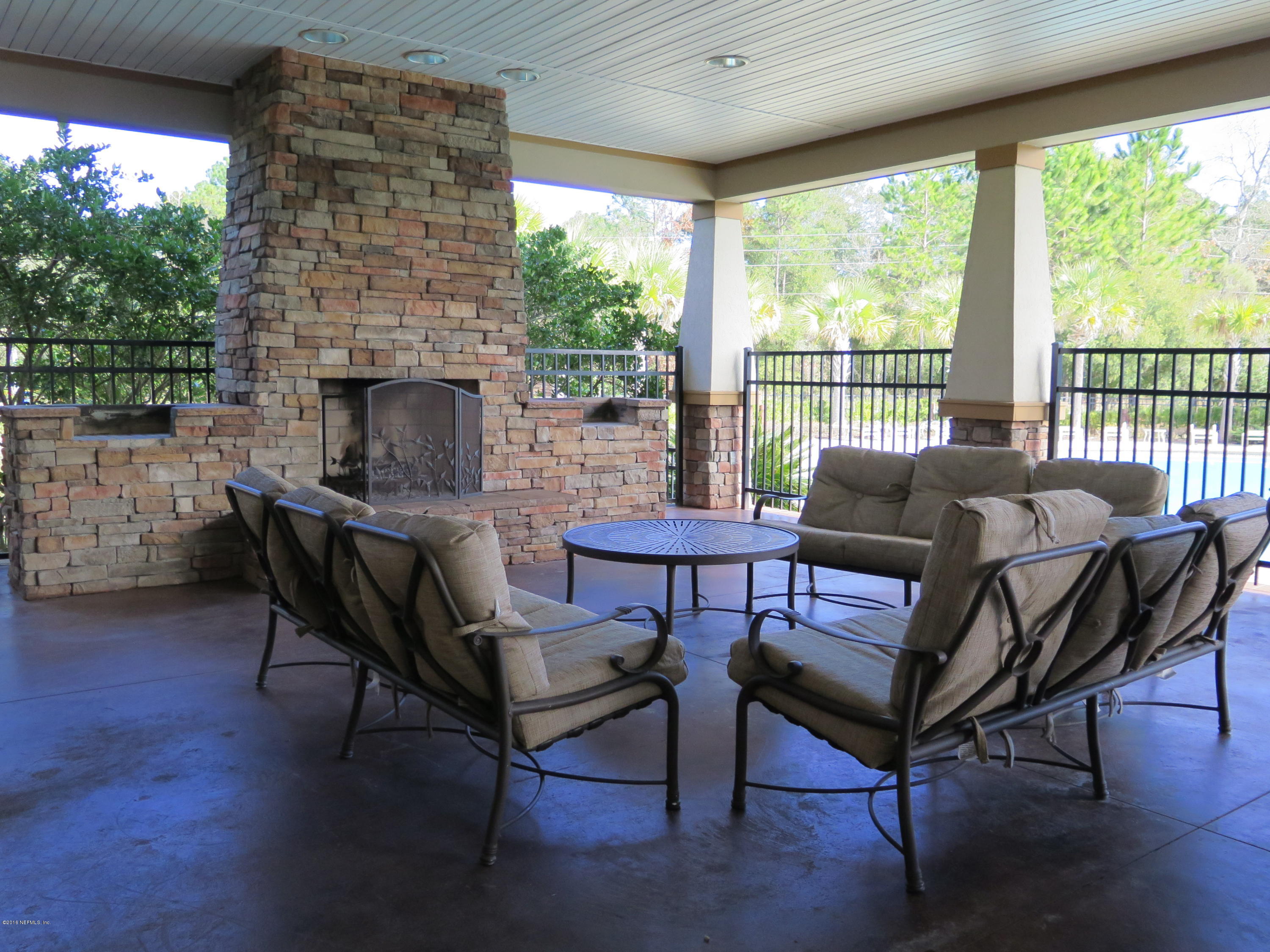 16504 Tisons Bluff Road Jacksonville, FL 32218 - Photo 32 of 34 a living room with furniture a fireplace and a floor to ceiling window