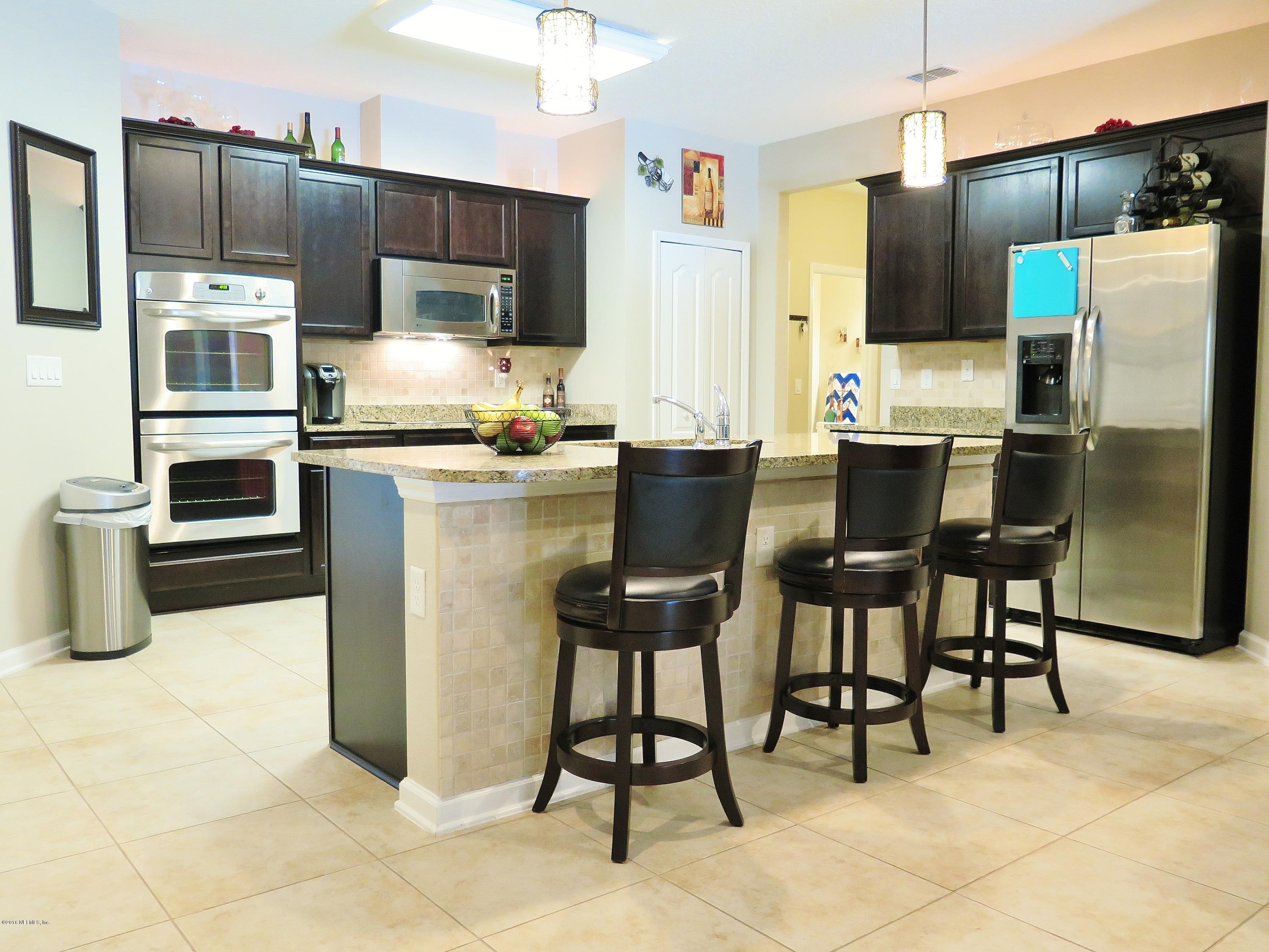 16504 Tisons Bluff Road Jacksonville, FL 32218 - Photo 8 of 34 a kitchen with stainless steel appliances a refrigerator stove microwave and cabinets
