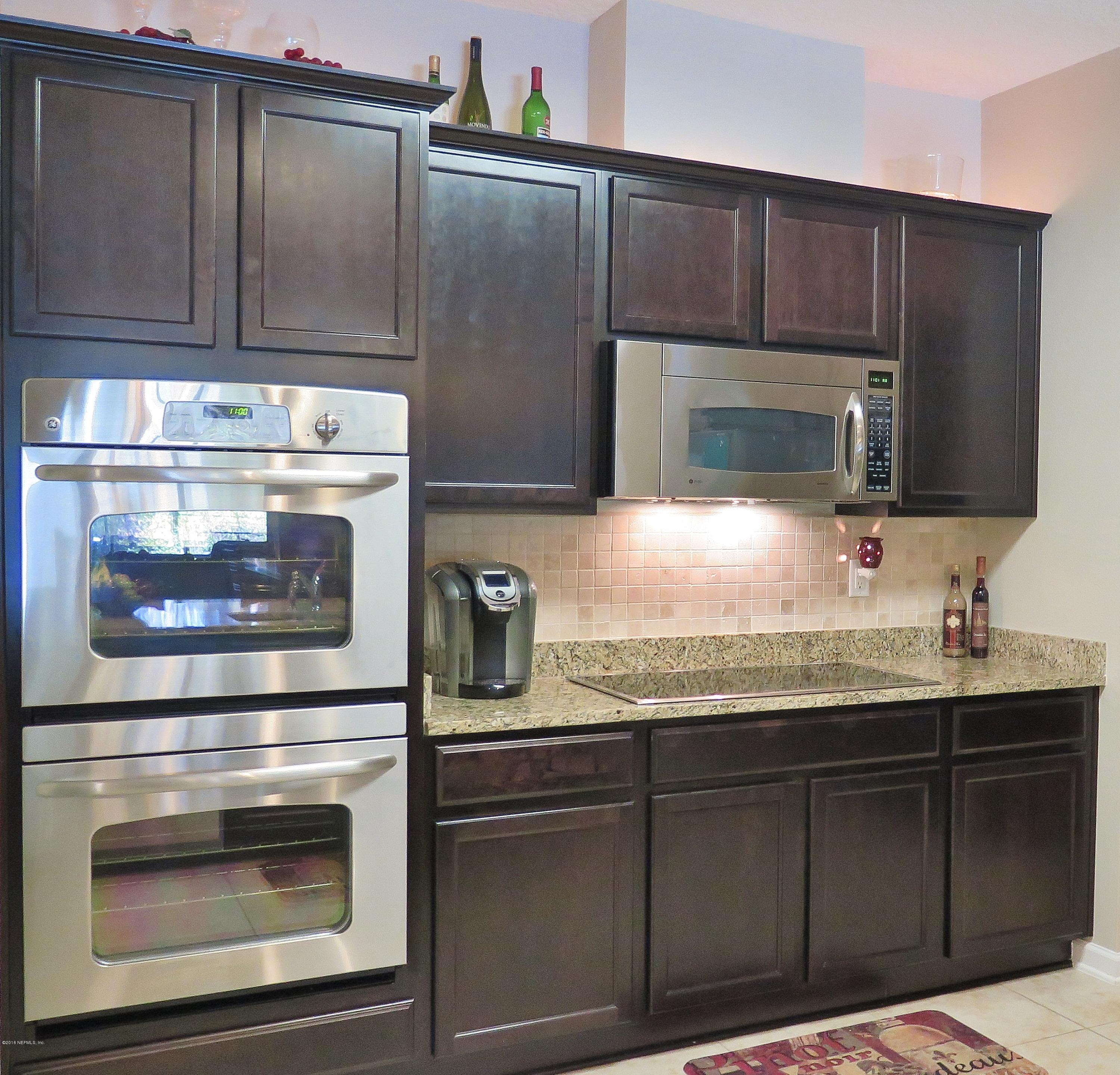 16504 Tisons Bluff Road Jacksonville, FL 32218 - Photo 9 of 34 a kitchen with granite countertop white cabinets and stainless steel appliances
