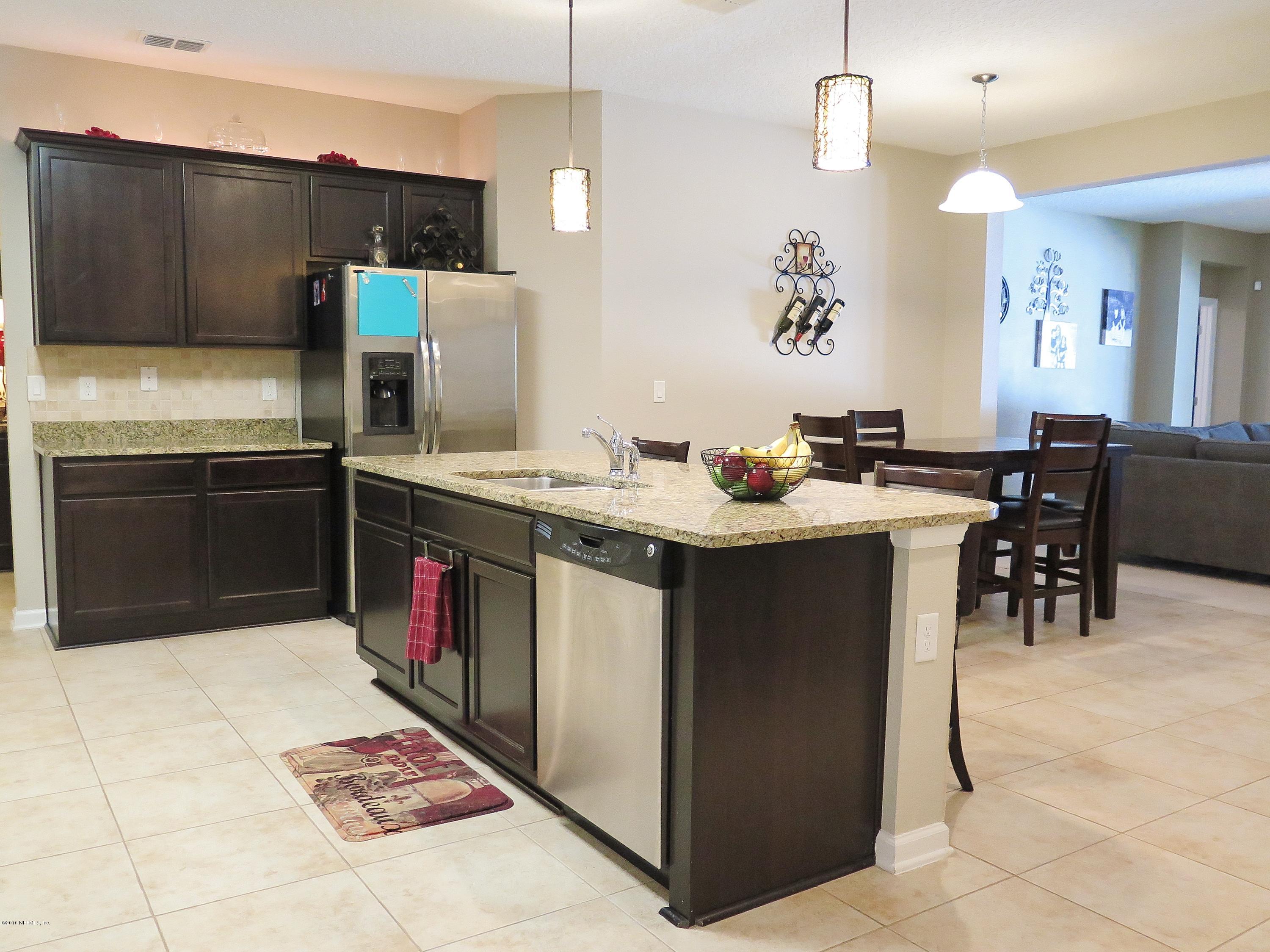 16504 Tisons Bluff Road Jacksonville, FL 32218 - Photo 10 of 34 a kitchen with stainless steel appliances granite countertop a sink a stove and a refrigerator
