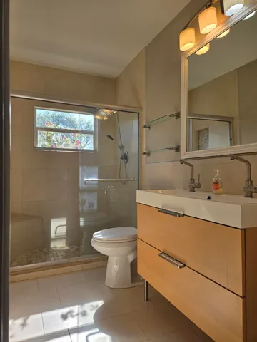 a bathroom with a sink mirror toilet and shower