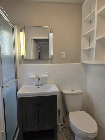 a bathroom with a sink a toilet and mirror