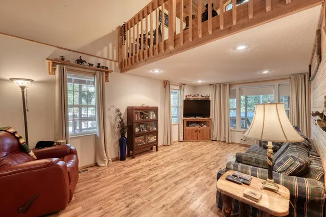 a living room with furniture a flat screen tv and a large window
