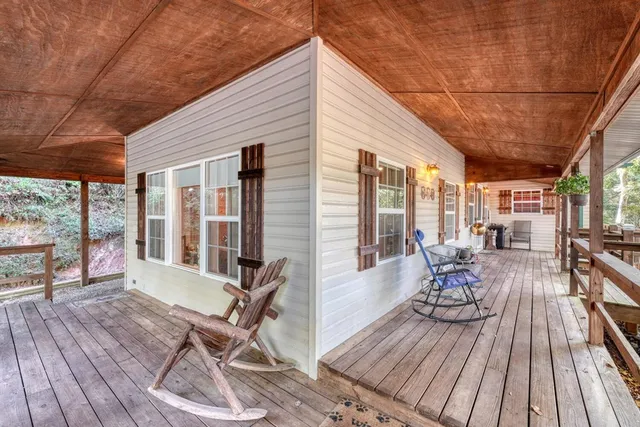 a view of backyard with a table and chairs under an umbrella
