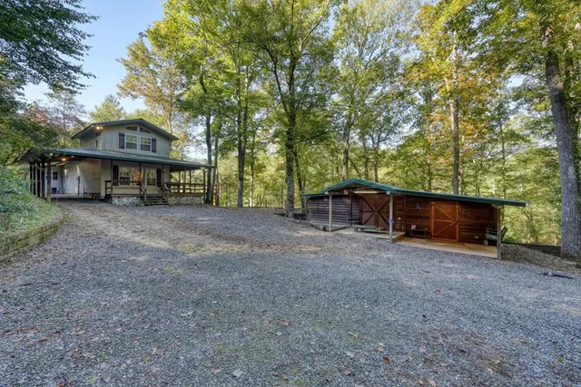 a view of a house with large trees and a barn
