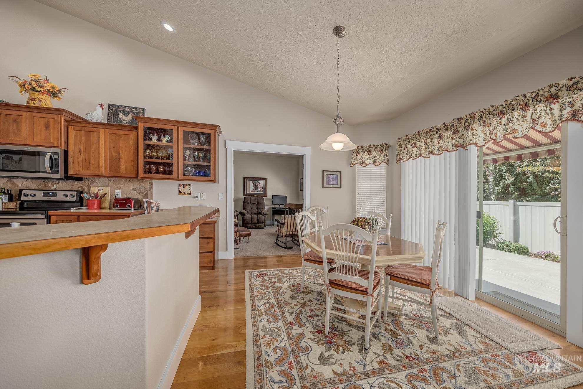 420 West Indianhead Road Weiser, ID 83672 - Photo 10 of 40 Kitchen and dining area featuring wood cabinetry, stainless steel appliances, and a breakfast bar