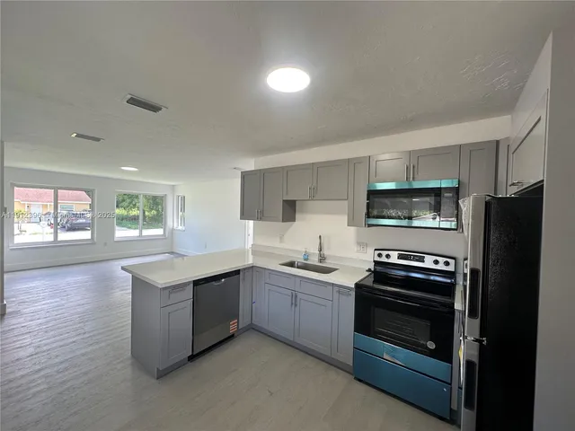 a kitchen with stainless steel appliances granite countertop a stove a refrigerator and a sink