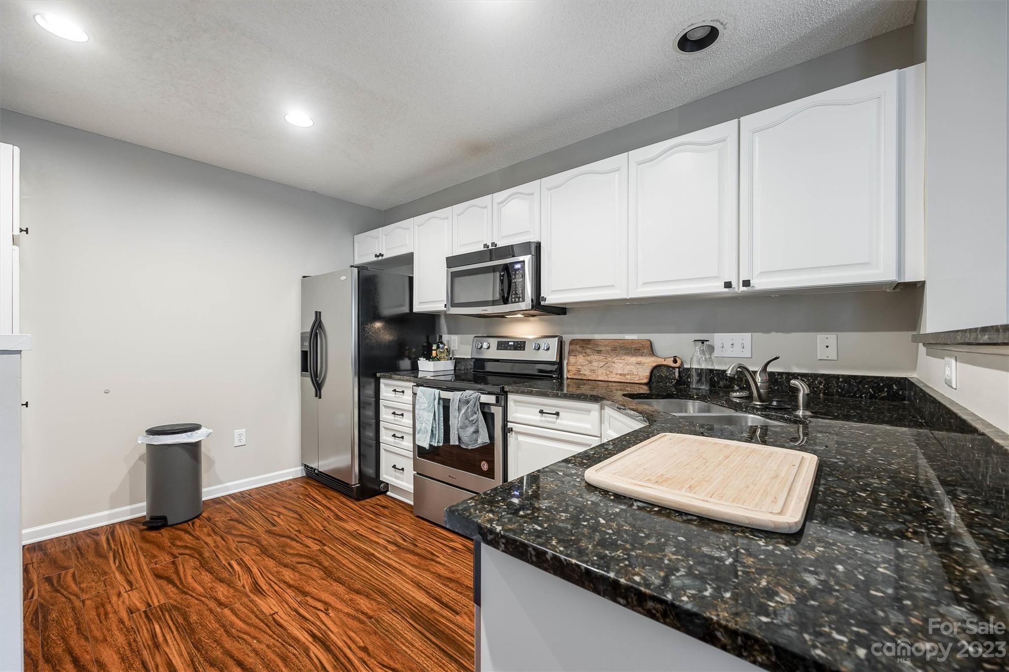 9725 Mattforest Circle Charlotte, NC 28277 - Photo 12 of 29 a kitchen with granite countertop a sink a stove top oven a counter space and cabinets