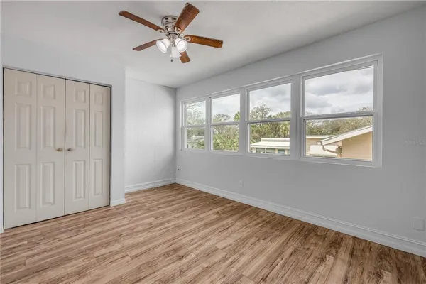 a view of an empty room with a window and wooden floor