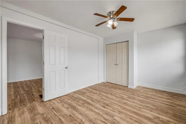 a view of a livingroom with wooden floor and a ceiling fan