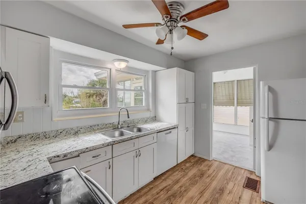 a kitchen with stainless steel appliances granite countertop a refrigerator a sink and a stove