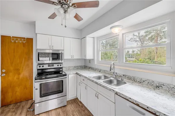 a kitchen with stainless steel appliances a stove a sink and a microwave