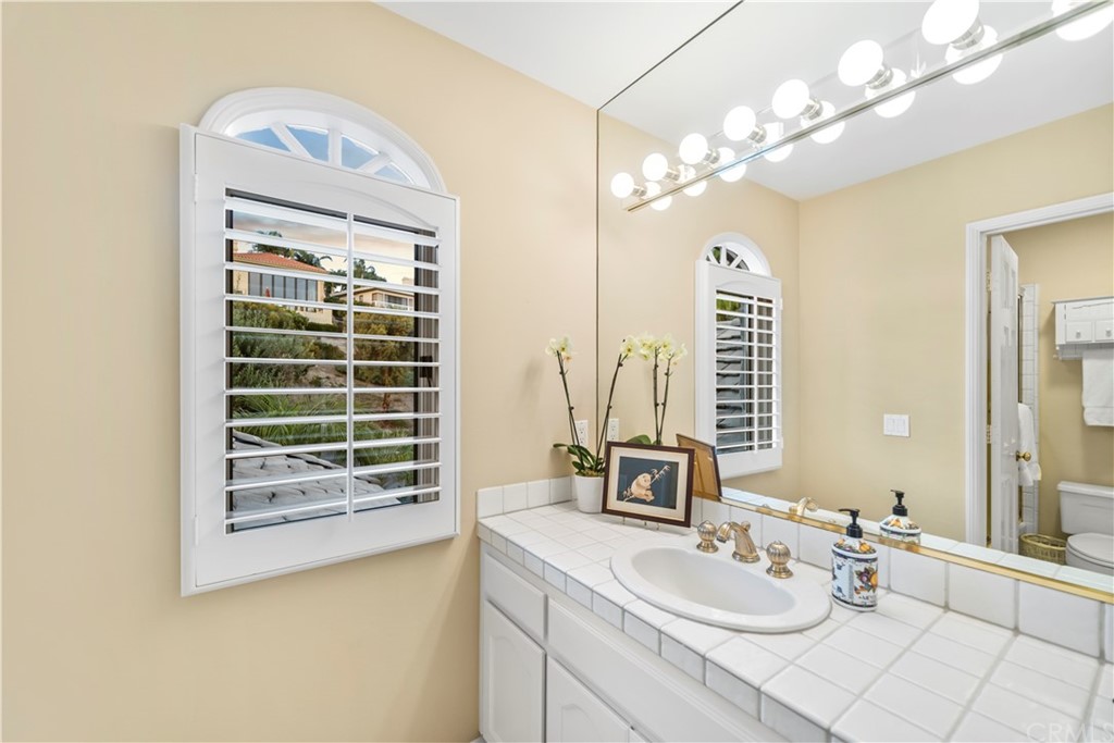 5 Marbella San Clemente, CA 92673 - Photo 27 of 49 a bathroom with a double vanity sink and a mirror
