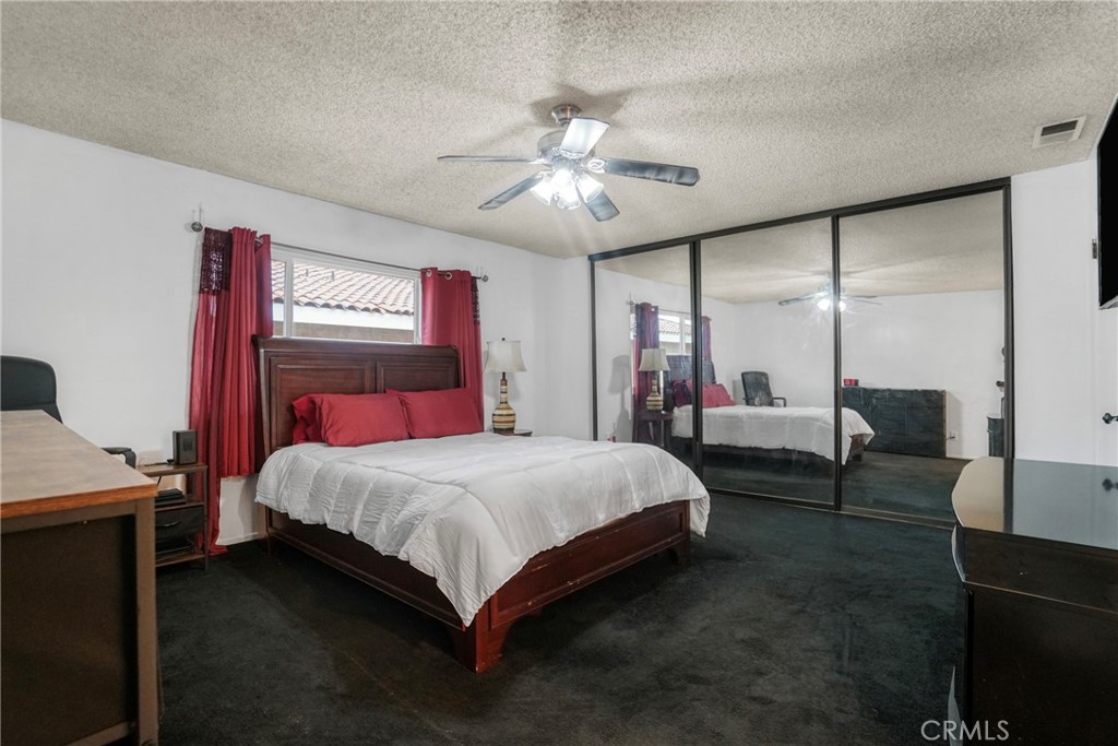 21602 South Figueroa Street, Unit 10 Carson, CA 90745 - Photo 14 of 25 a bedroom with a bed and a chandelier