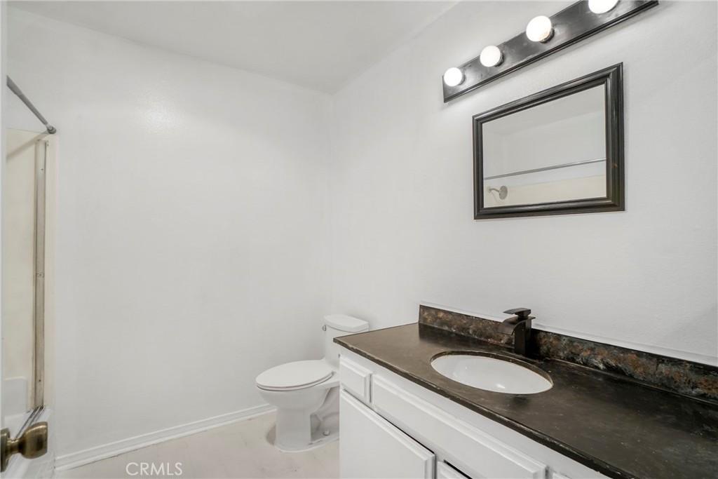 21602 South Figueroa Street, Unit 10 Carson, CA 90745 - Photo 16 of 25 a bathroom with a toilet a sink and mirror