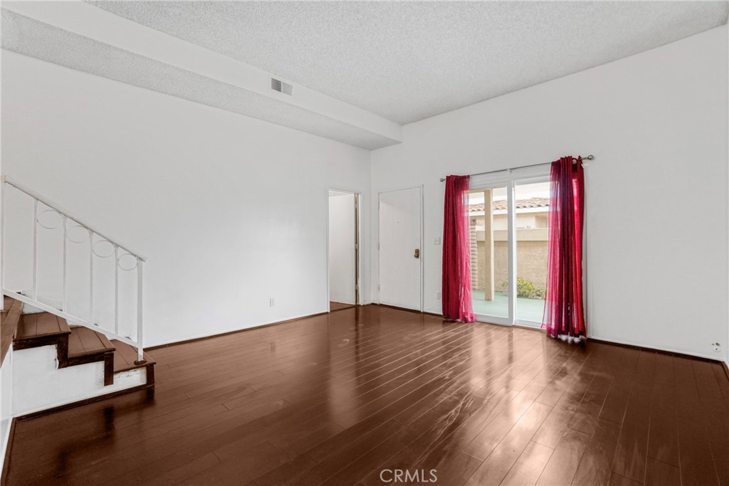 21602 South Figueroa Street, Unit 10 Carson, CA 90745 - Photo 4 of 25 an empty room with wooden floor and windows