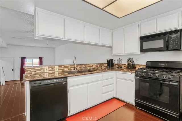 a kitchen with stainless steel appliances granite countertop a stove sink and cabinets