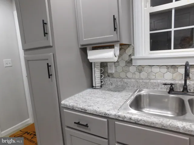 a kitchen with granite countertop a sink stove and refrigerator