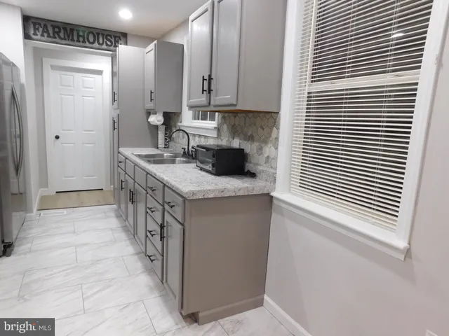 a view of a patio with a table and chairs and wooden fence