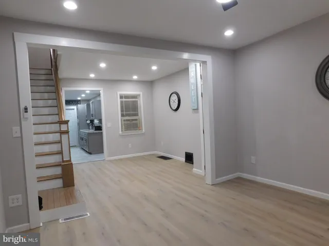 an empty room with wooden floor and a window