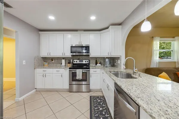 a kitchen with a sink a stove and cabinets