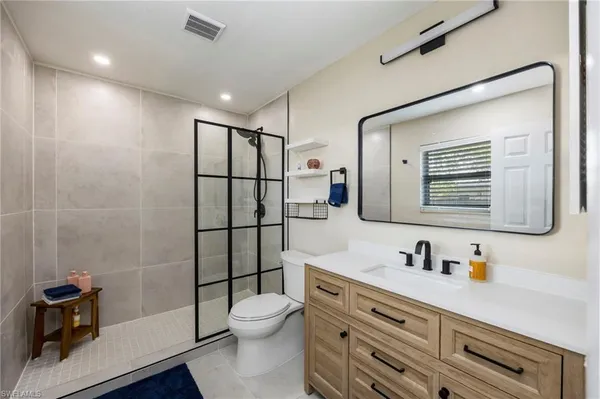 a bathroom with a sink a toilet and shower