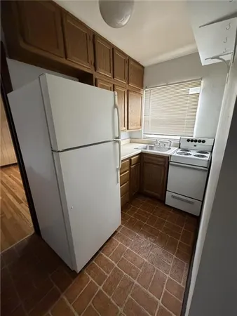 a white refrigerator freezer and a stove sitting inside of a kitchen