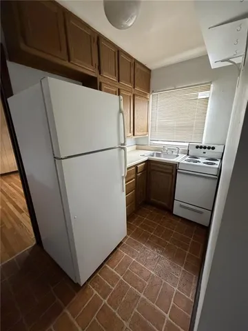 a white refrigerator freezer and a stove sitting inside of a kitchen