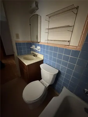 a bathroom with a toilet a sink and mirror