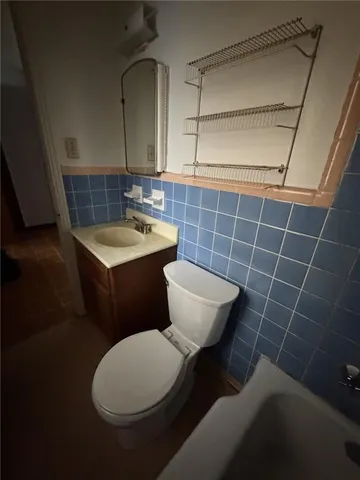 a bathroom with a toilet a sink and mirror