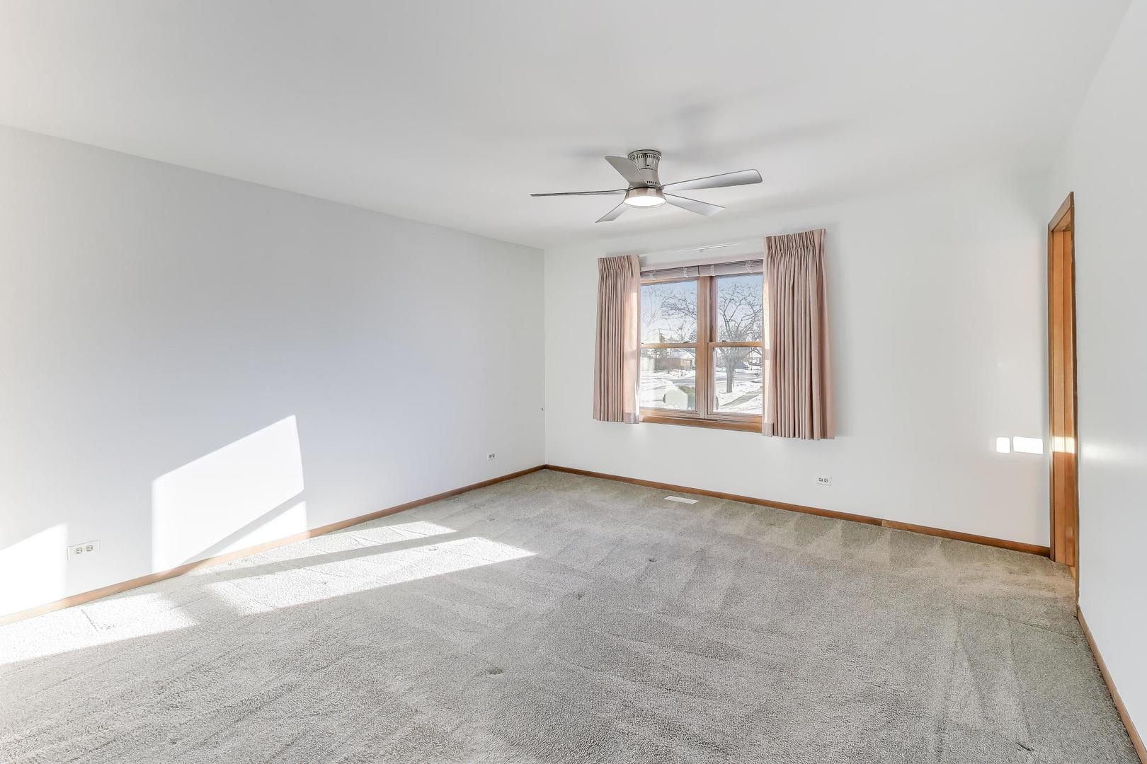 549 Ridgewood Lane Buffalo Grove, IL 60089 - Photo 11 of 17 an empty room with windows and ceiling fan