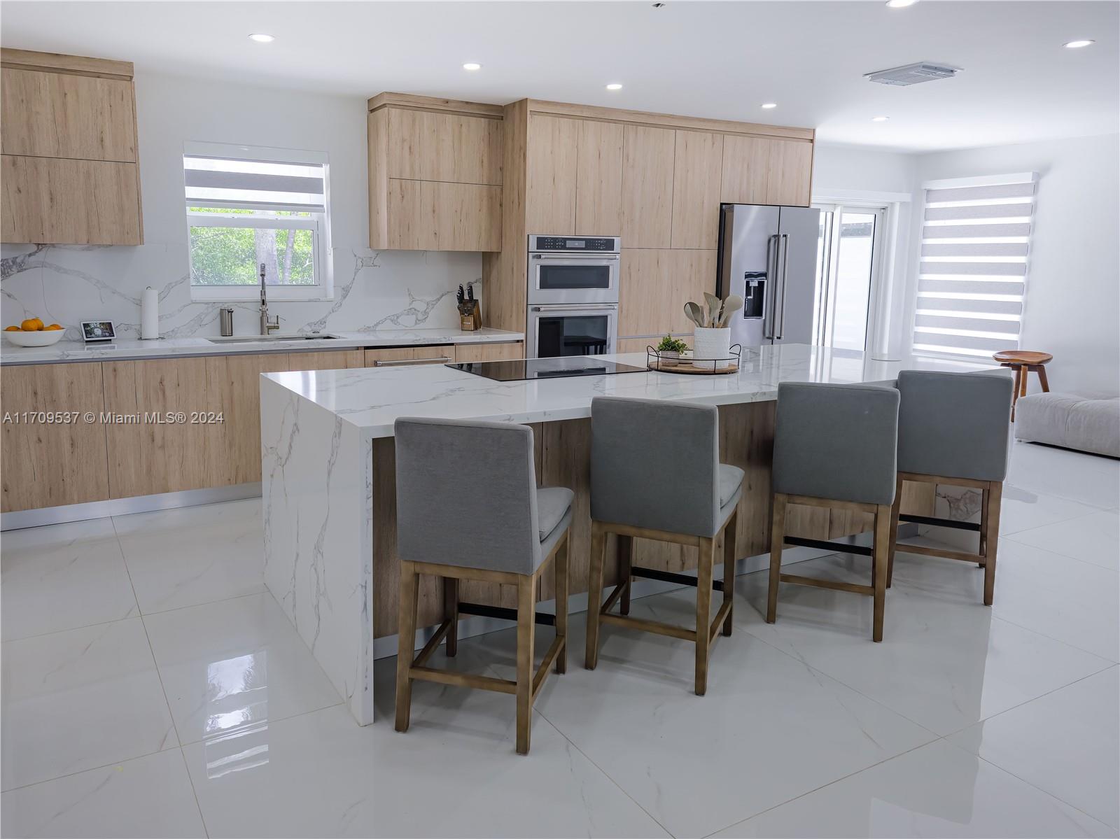 18199 Southwest 3rd Street Pembroke Pines, FL 33029 - Photo 7 of 31 a kitchen with dining table chairs sink and cabinets