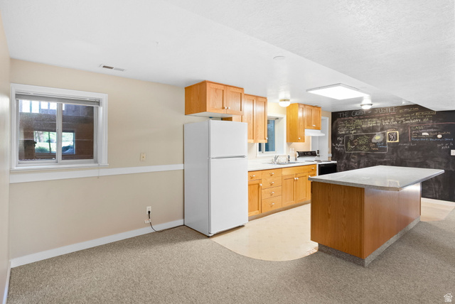 435 Canyon Road Millville, UT 84326 - Photo 40 of 113 Well-appointed kitchen featuring wood cabinetry, white appliances, and a central island with a light-colored countertop