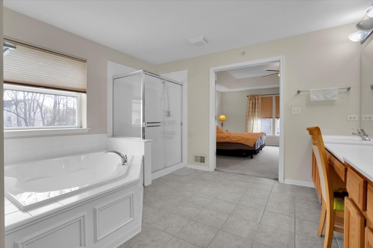 7 Springbrook Court Streamwood, IL 60107 - Photo 23 of 36 a en suite bathroom with a granite countertop tub and a sink