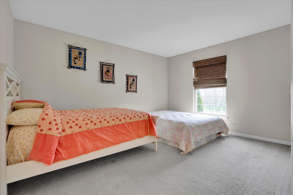 7 Springbrook Court Streamwood, IL 60107 - Photo 26 of 36 a bed sitting in a bedroom next to a window