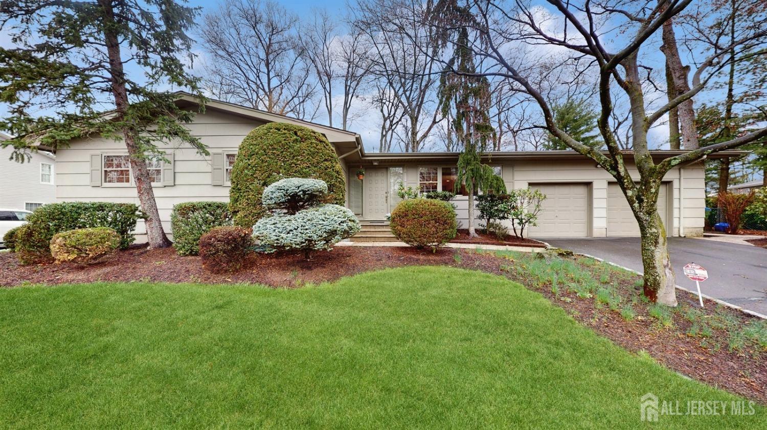 a front view of a house with a garden and plants
